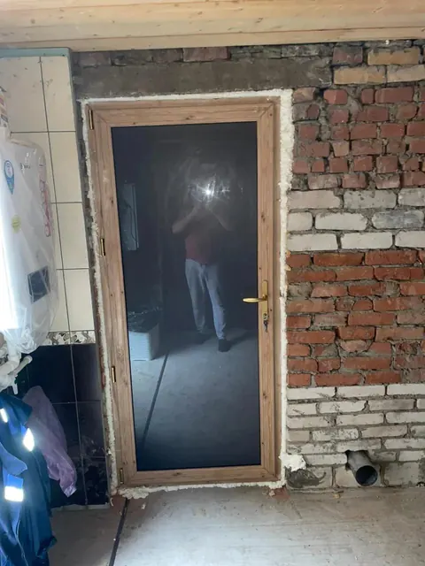 Тёмная дверь со стороны кирпичного помещения